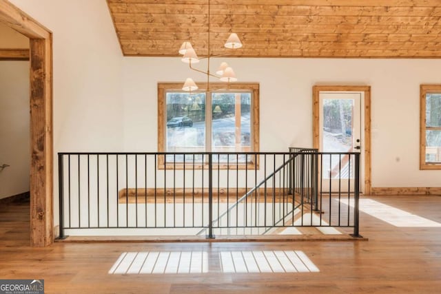 interior space with vaulted ceiling, wood ceiling, wood finished floors, and baseboards