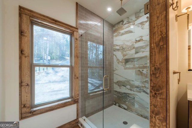 bathroom featuring plenty of natural light, vanity, and a shower stall