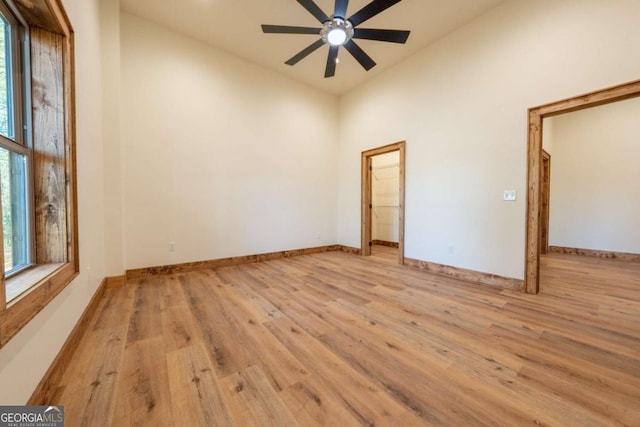 spare room with light wood-style floors, baseboards, and a healthy amount of sunlight