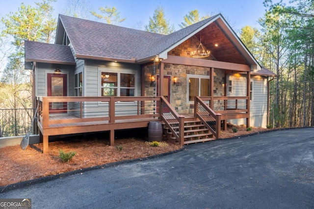 chalet / cabin featuring stone siding and a shingled roof