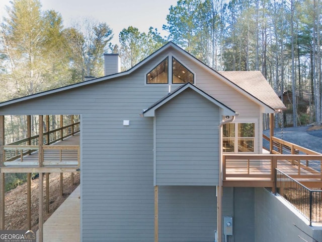 view of side of home featuring a deck and a chimney