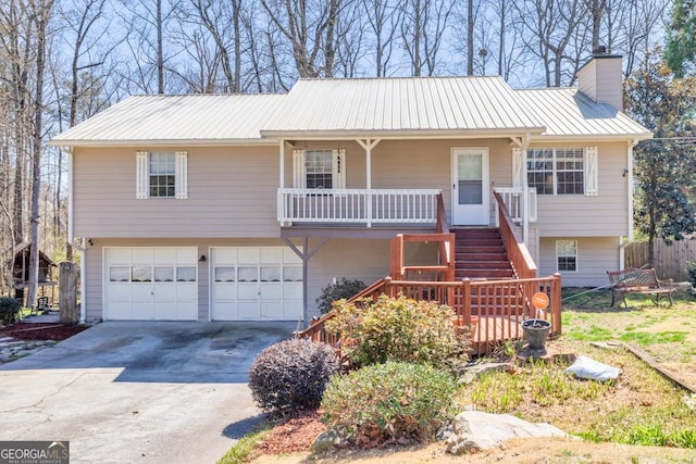 view of front of house with a garage, stairway, concrete driveway, metal roof, and a chimney