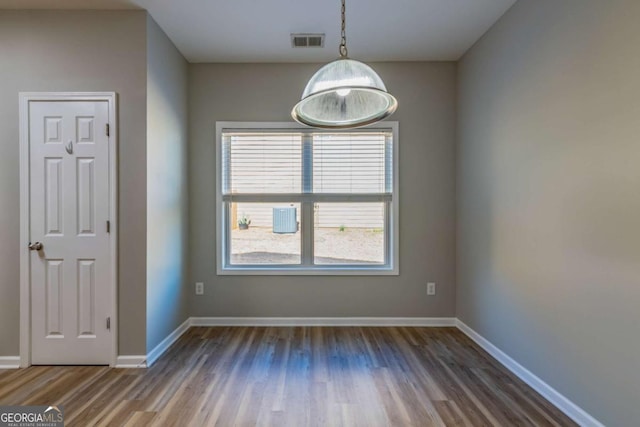 unfurnished room with wood finished floors, visible vents, and baseboards