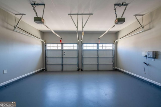 garage featuring a garage door opener and baseboards