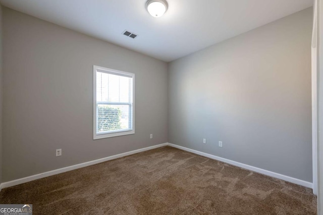 empty room featuring baseboards, visible vents, and carpet floors