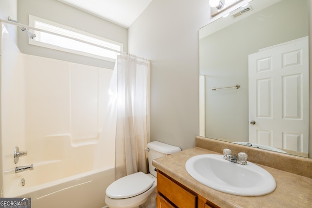 full bath with visible vents, vanity, toilet, and shower / tub combo