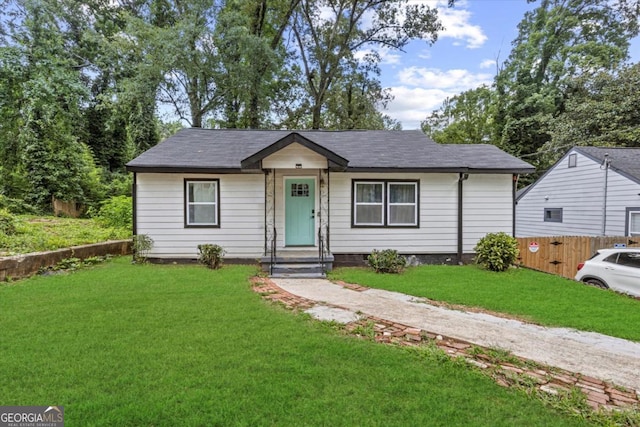 view of front facade featuring a front lawn and fence