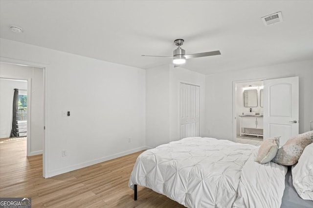 bedroom with a ceiling fan, visible vents, baseboards, light wood-style floors, and connected bathroom