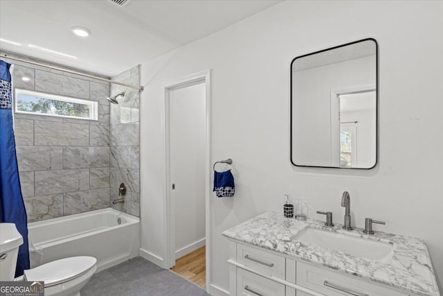 bathroom featuring shower / bath combination with curtain, toilet, vanity, and baseboards