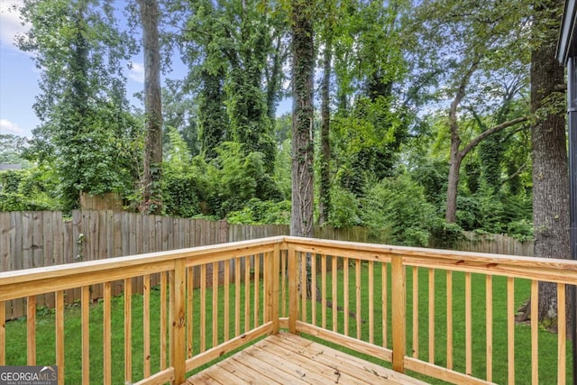 wooden terrace with a lawn and a fenced backyard