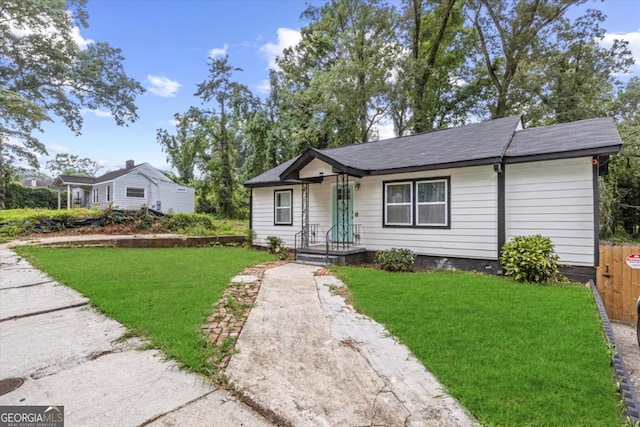 view of front of home with a front lawn and fence