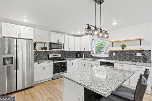 kitchen with open shelves, stainless steel appliances, light wood-type flooring, and white cabinetry