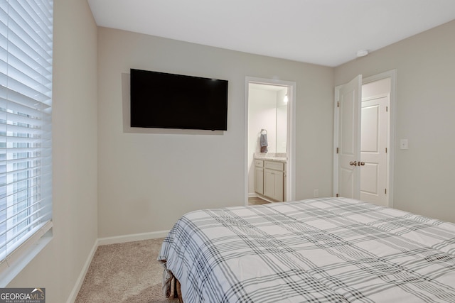 bedroom featuring connected bathroom, baseboards, and carpet