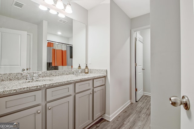 bathroom featuring visible vents, wood finished floors, and a sink