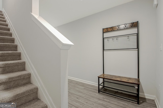 stairway featuring wood finished floors and baseboards