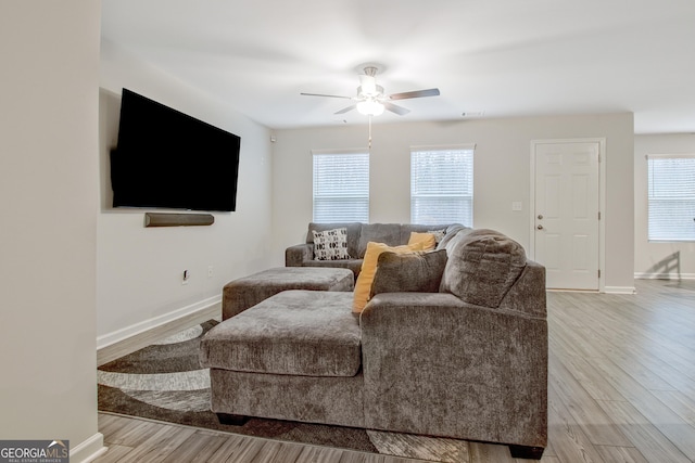 living room featuring visible vents, baseboards, a ceiling fan, and wood finished floors