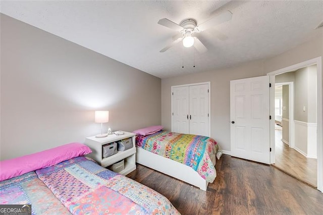 bedroom with a closet, a textured ceiling, ceiling fan, and wood finished floors