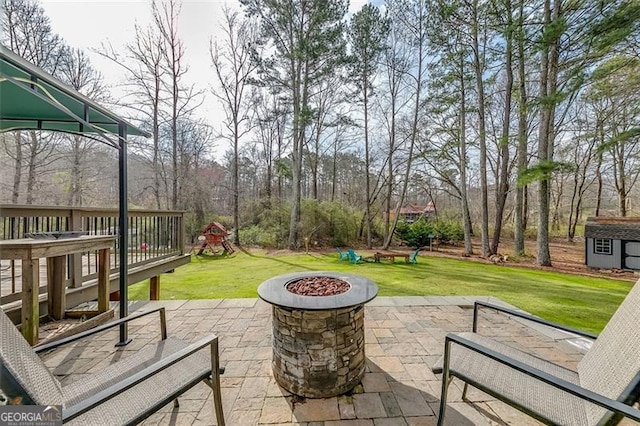 view of patio featuring an outbuilding, a storage shed, and an outdoor fire pit