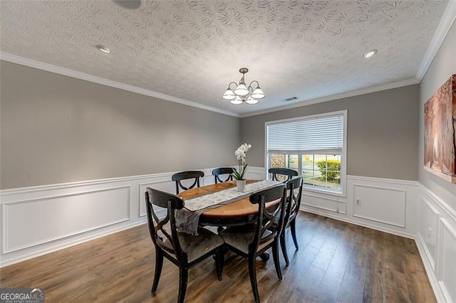 dining space featuring visible vents, a textured ceiling, wainscoting, a chandelier, and dark wood-style flooring