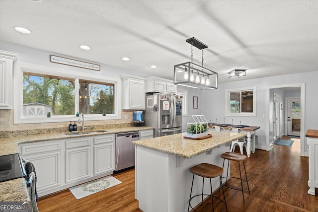 kitchen featuring a sink, dark wood-type flooring, white cabinets, and stainless steel appliances