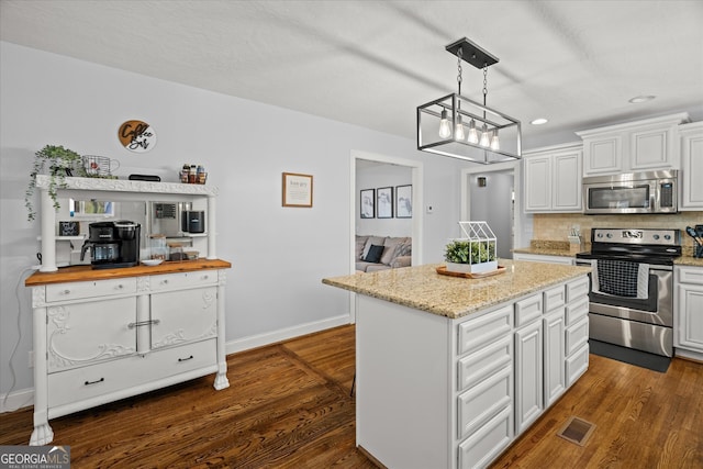 kitchen featuring visible vents, backsplash, dark wood-style floors, appliances with stainless steel finishes, and baseboards