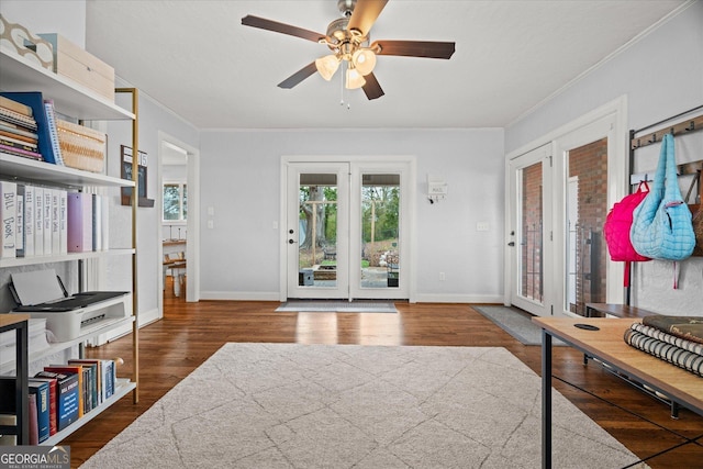 foyer entrance with baseboards, wood finished floors, a ceiling fan, and crown molding