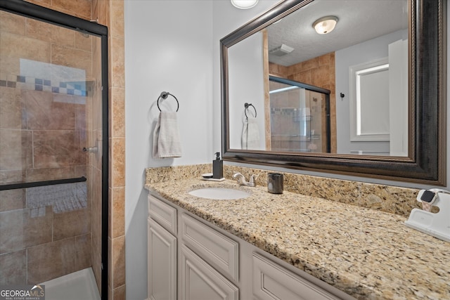 full bath featuring visible vents, a shower stall, and vanity