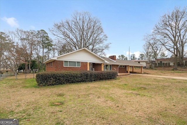 view of front of property featuring a front lawn, a carport, fence, brick siding, and a chimney