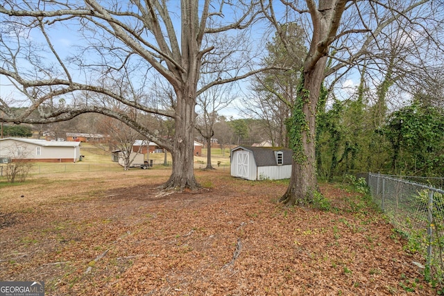 view of yard with an outbuilding, fence, and a shed