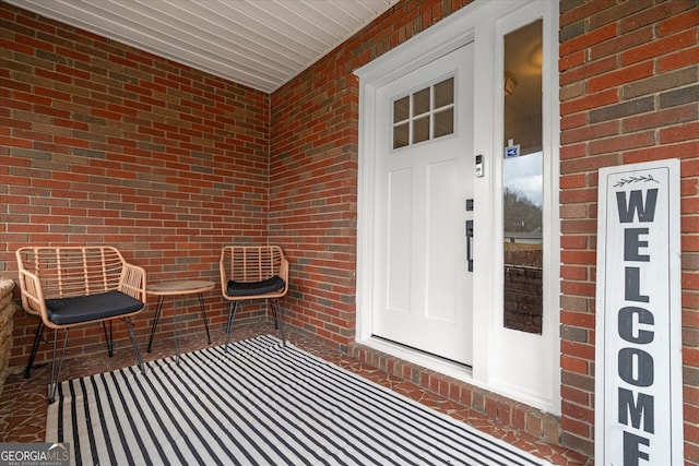 doorway to property with brick siding