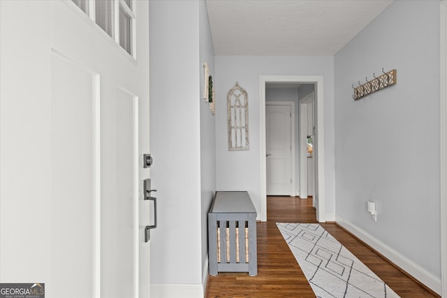 hallway featuring wood finished floors and baseboards