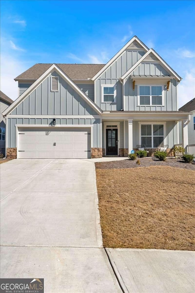 view of front facade featuring concrete driveway, an attached garage, and board and batten siding