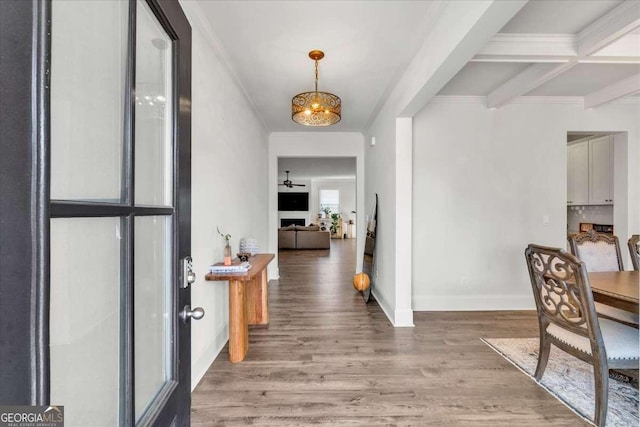 foyer with crown molding, baseboards, beamed ceiling, light wood-type flooring, and a notable chandelier