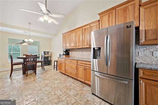 kitchen with lofted ceiling, tasteful backsplash, ceiling fan with notable chandelier, and stainless steel refrigerator with ice dispenser