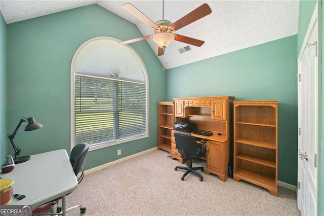 office featuring a ceiling fan, visible vents, lofted ceiling, a textured ceiling, and light colored carpet