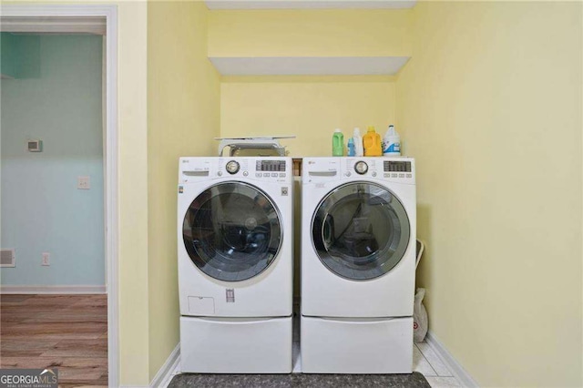 washroom with laundry area, independent washer and dryer, visible vents, and baseboards