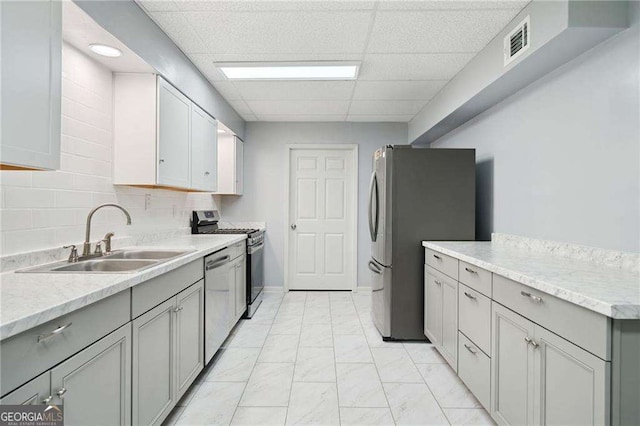 kitchen with gray cabinets, visible vents, appliances with stainless steel finishes, and a sink