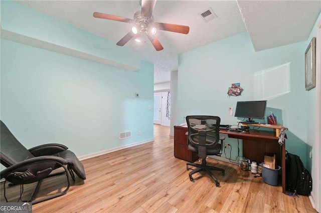 home office featuring visible vents, baseboards, wood finished floors, and a ceiling fan