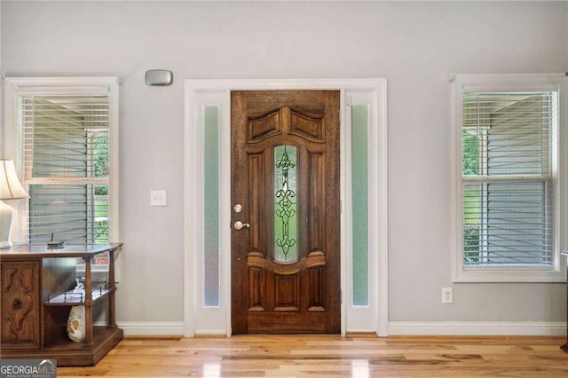 entryway featuring baseboards and wood finished floors