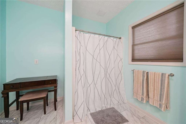 bathroom with a textured ceiling and a shower with shower curtain