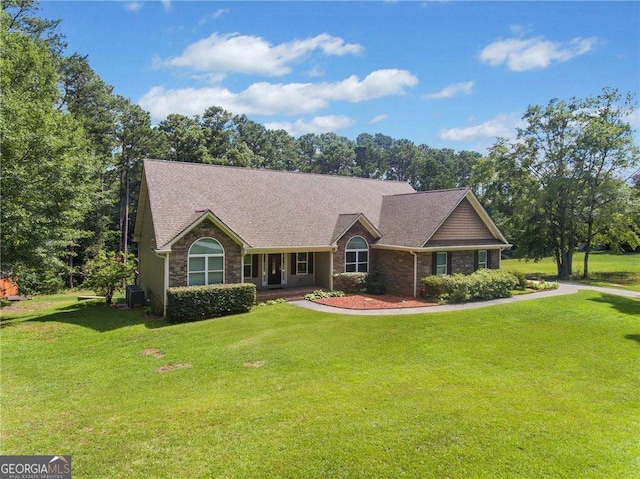 ranch-style home with brick siding, central AC, a front lawn, and a shingled roof