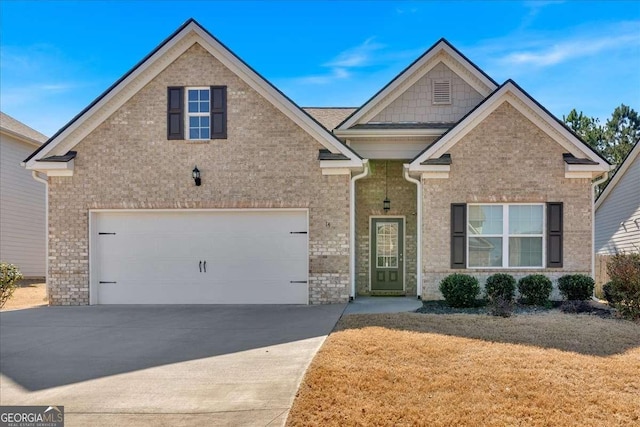 craftsman house with brick siding, driveway, a front yard, and a garage