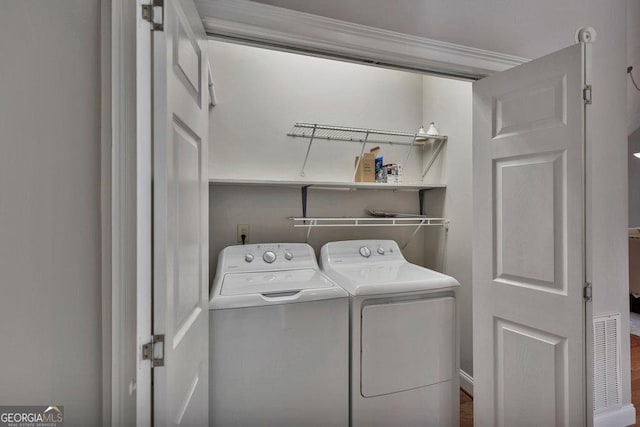 laundry area with laundry area, visible vents, and washing machine and clothes dryer