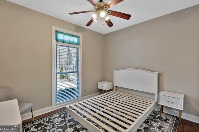 bedroom with ceiling fan, baseboards, and wood finished floors