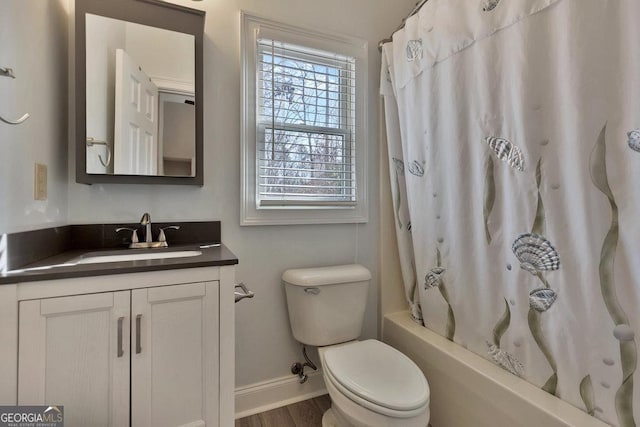 full bathroom with toilet, wood finished floors, shower / tub combo, baseboards, and vanity