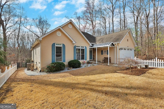 view of front of property with a front lawn, a garage, and fence