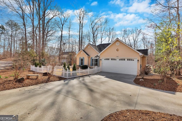 ranch-style house with a fenced front yard, brick siding, a garage, and driveway