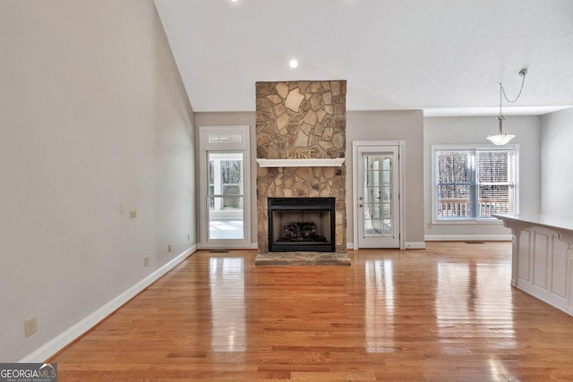 unfurnished living room featuring light wood-style flooring, a fireplace, and baseboards