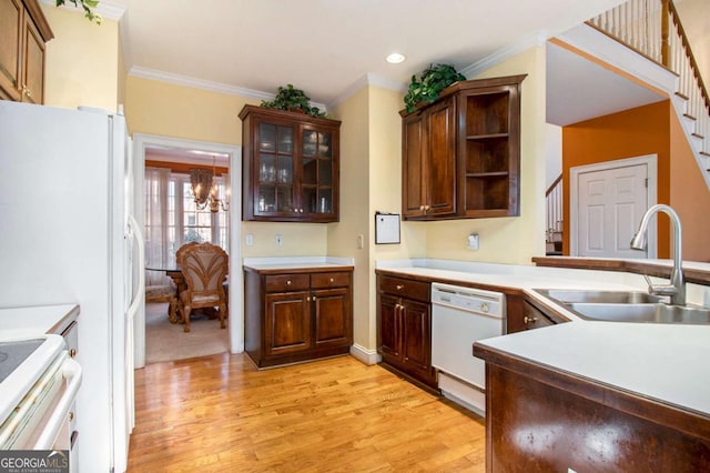 kitchen featuring ornamental molding, white appliances, light wood-style floors, and a sink