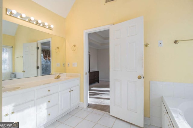 full bathroom with tile patterned floors, lofted ceiling, a tub to relax in, and double vanity